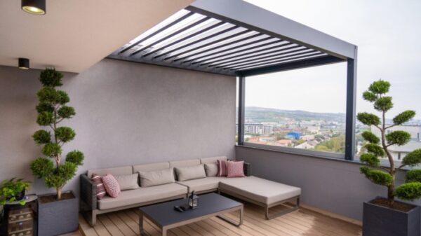 Terraza moderna con pérgola de aluminio y plantas para ganar privacidad en el exterior.